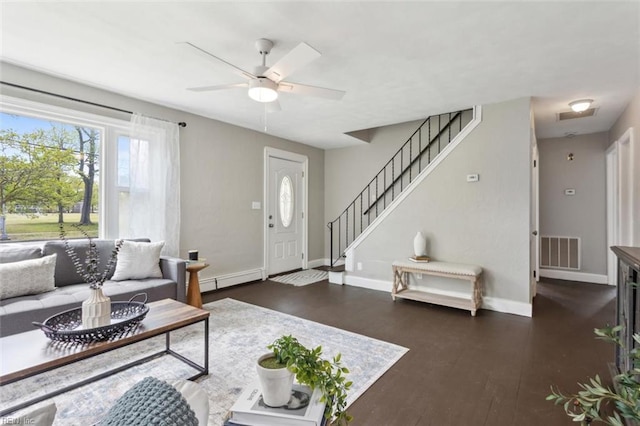 living room featuring dark wood-type flooring, visible vents, baseboards, and a ceiling fan