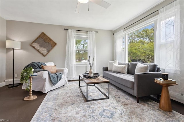 living room with a baseboard radiator, ceiling fan, and baseboards