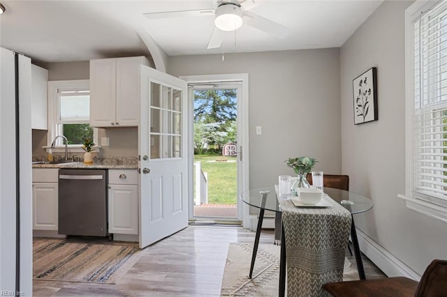 dining space with baseboard heating, a baseboard radiator, light wood finished floors, and ceiling fan