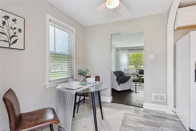 dining room with visible vents, baseboards, light wood-type flooring, and a ceiling fan