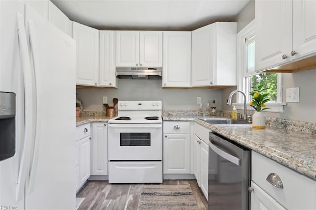 kitchen with white appliances, white cabinets, under cabinet range hood, a sink, and light wood finished floors