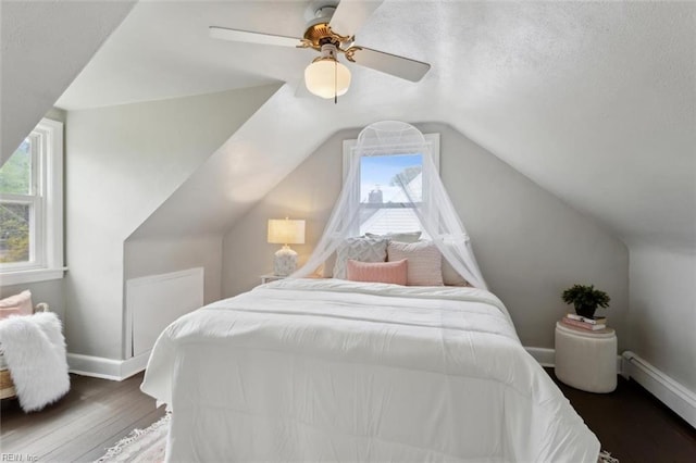 bedroom with baseboards, a ceiling fan, vaulted ceiling, and wood finished floors