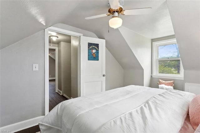 bedroom with baseboards, wood finished floors, ceiling fan, and vaulted ceiling