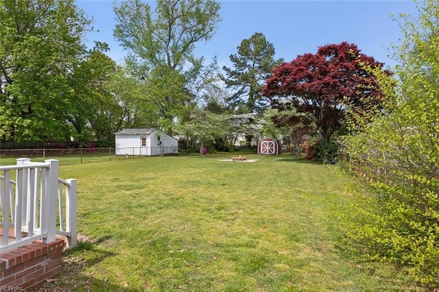 view of yard featuring a storage shed, a fenced backyard, and an outdoor structure