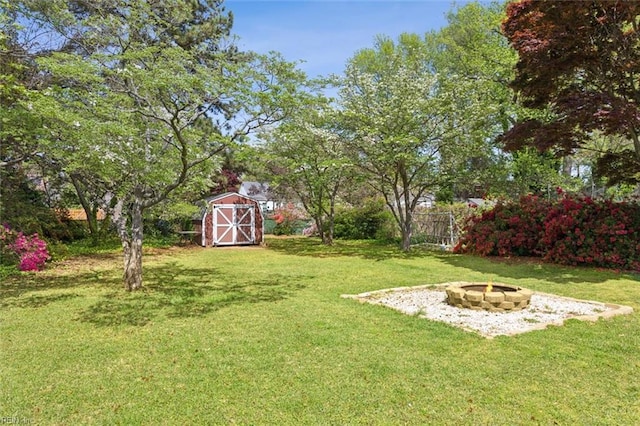 view of yard with an outbuilding, a shed, and a fire pit
