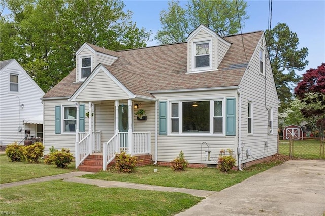 new england style home featuring crawl space, a shingled roof, a front yard, and fence