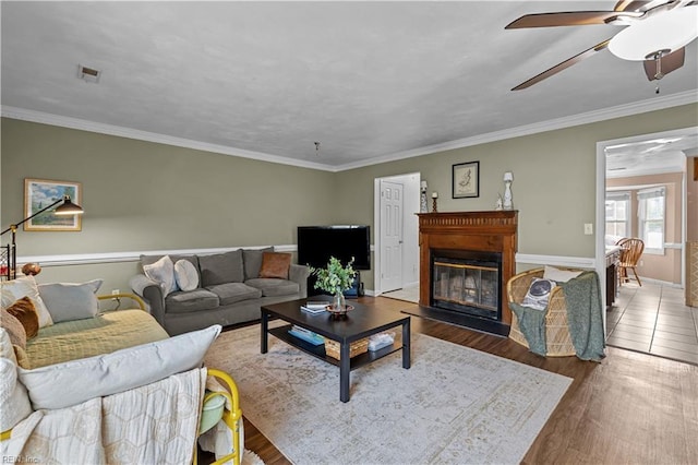 1206 Mabry Mill Pl, Chesapeake, VA 23320 - living area featuring a glass covered fireplace, baseboards, crown molding, ceiling fan, and wood finished floors