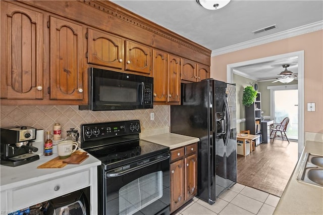 1206 Mabry Mill Pl, Chesapeake, VA 23320 - kitchen featuring light countertops, crown molding, visible vents, brown cabinetry, and black appliances