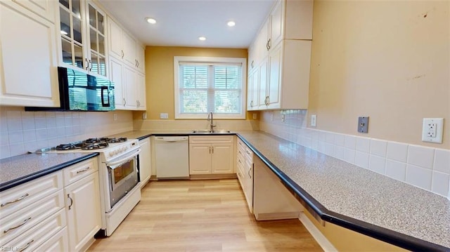 301 Brooke Ave Unit 105, Norfolk, VA 23510 - kitchen with a sink, white cabinets, white appliances, and decorative backsplash