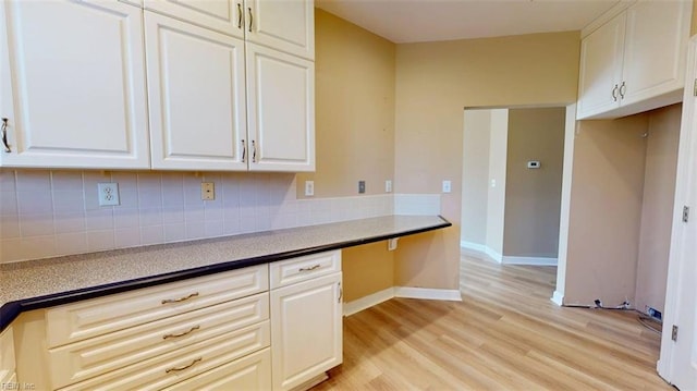 301 Brooke Ave Unit 105, Norfolk, VA 23510 - kitchen featuring white cabinets, light wood-style flooring, decorative backsplash, and baseboards