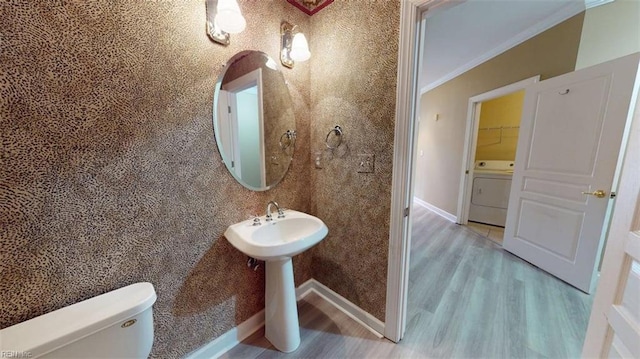 301 Brooke Ave Unit 105, Norfolk, VA 23510 - half bath featuring washer / clothes dryer, ornamental molding, toilet, wood finished floors, and baseboards