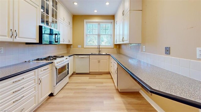 301 Brooke Ave Unit 105, Norfolk, VA 23510 - kitchen with recessed lighting, white appliances, white cabinetry, backsplash, and a sink