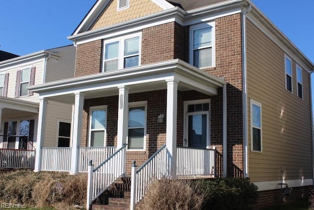 view of front facade featuring brick siding and covered porch