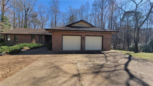 view of front of house featuring brick siding, an attached garage, and driveway