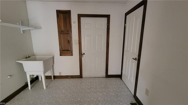 clothes washing area with baseboards