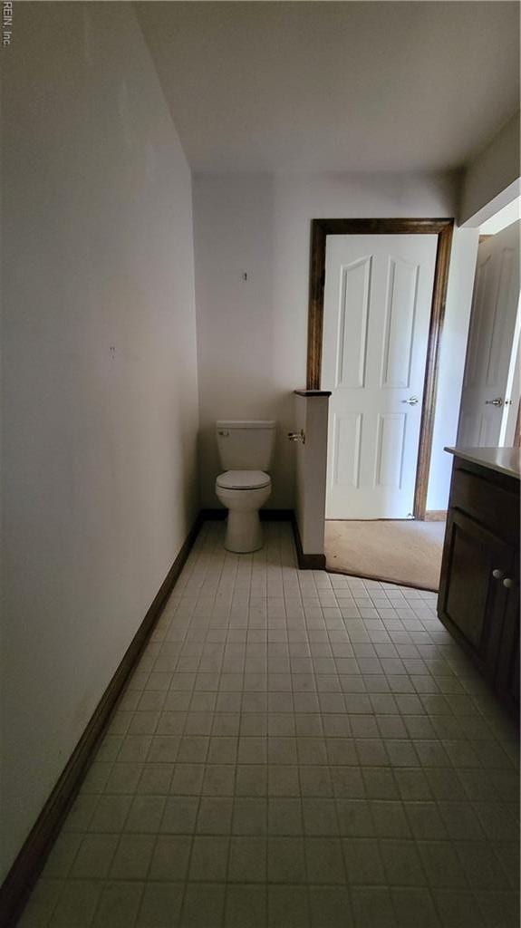 bathroom featuring vanity, baseboards, and toilet