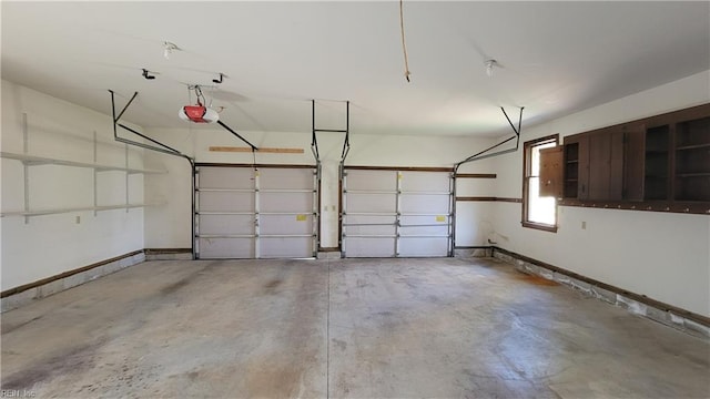 garage with a garage door opener and baseboards