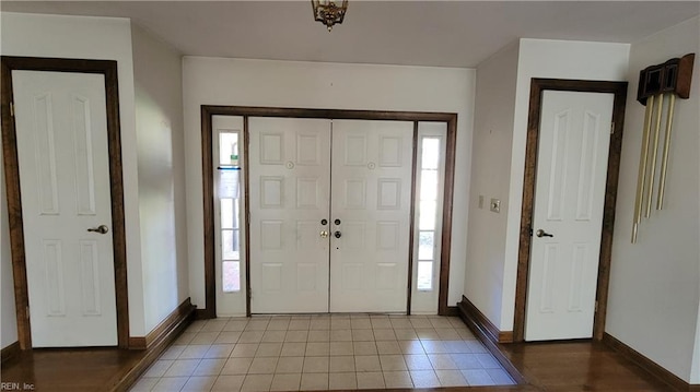 entrance foyer featuring a wealth of natural light, light tile patterned floors, and baseboards
