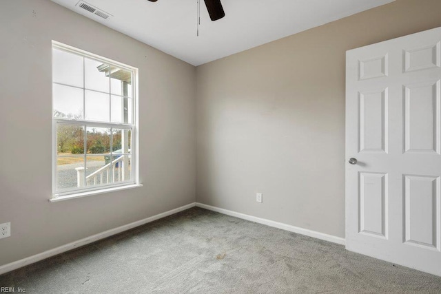carpeted spare room featuring baseboards, a ceiling fan, and visible vents