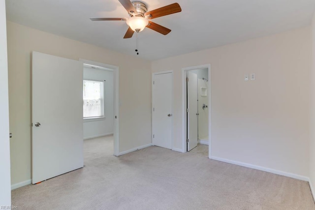 empty room with light colored carpet, baseboards, and a ceiling fan