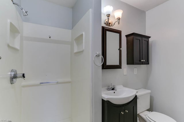 full bathroom with toilet, vanity, and walk in shower