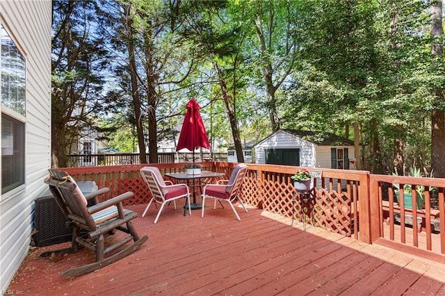 106 Elm Tree Ct, Suffolk, VA 23435 - wooden terrace with a storage shed, an outbuilding, a garage, and outdoor dining area