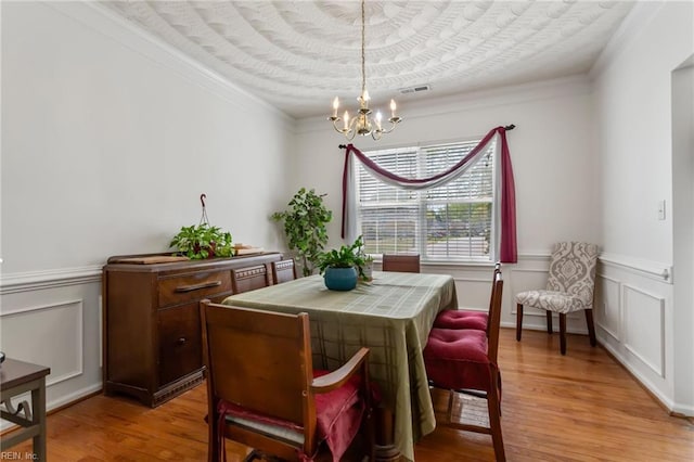 106 Elm Tree Ct, Suffolk, VA 23435 - dining space featuring visible vents, a notable chandelier, light wood-type flooring, crown molding, and wainscoting
