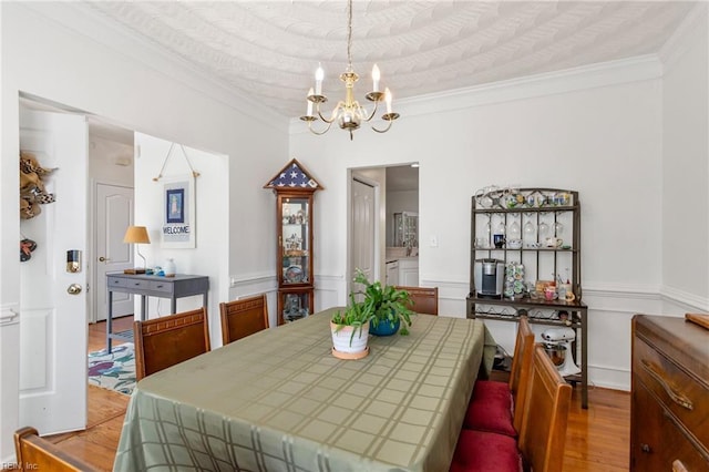 106 Elm Tree Ct, Suffolk, VA 23435 - dining space with light wood-style floors, a notable chandelier, ornamental molding, and a wainscoted wall