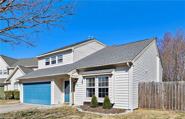 view of front of home with fence, roof with shingles, and driveway