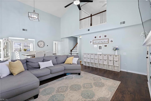 living area with wood finished floors, visible vents, high vaulted ceiling, and ceiling fan with notable chandelier