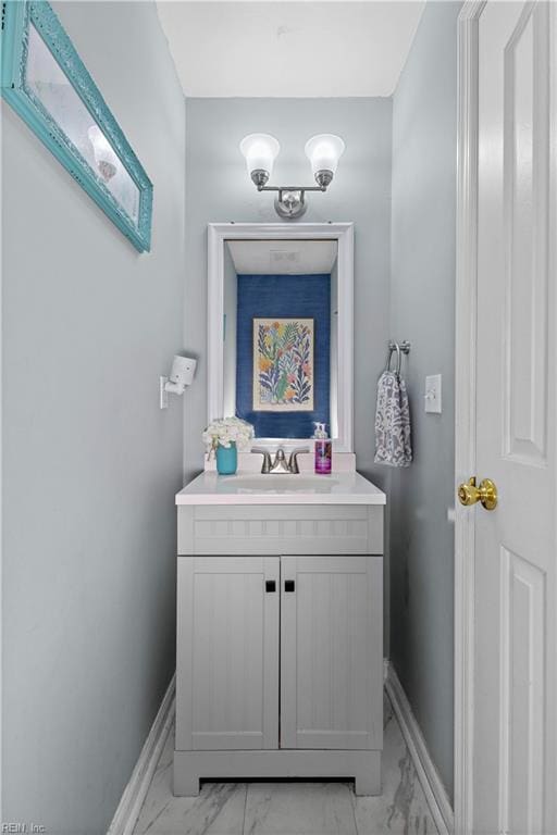 bathroom with baseboards, marble finish floor, and vanity