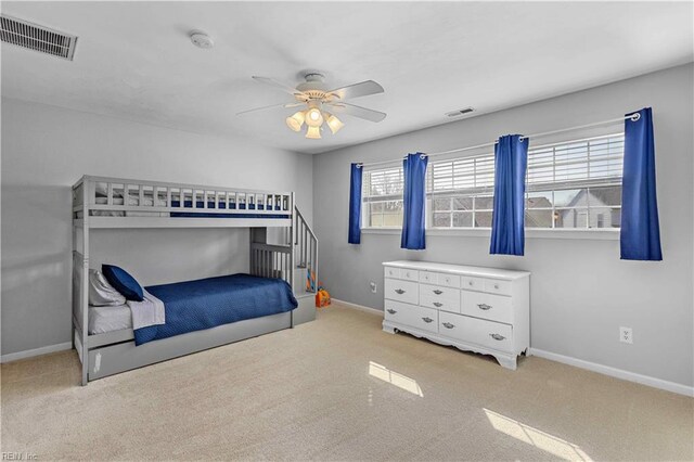 carpeted bedroom with visible vents, a ceiling fan, and baseboards