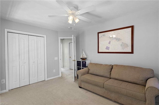 living room with ceiling fan, light carpet, and baseboards