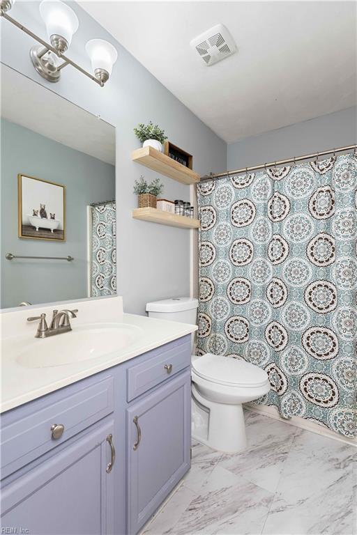 bathroom with curtained shower, marble finish floor, visible vents, toilet, and vanity