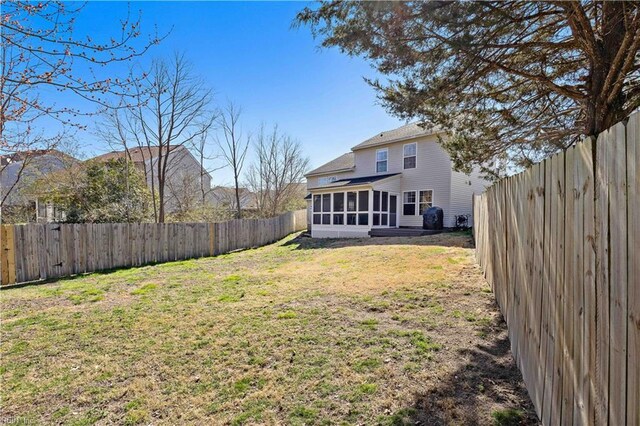 view of yard with a fenced backyard and a sunroom