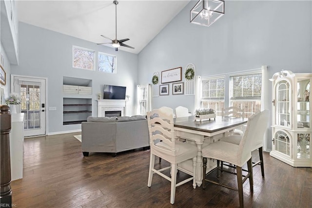 dining area featuring dark wood-type flooring, a wealth of natural light, a ceiling fan, and high vaulted ceiling