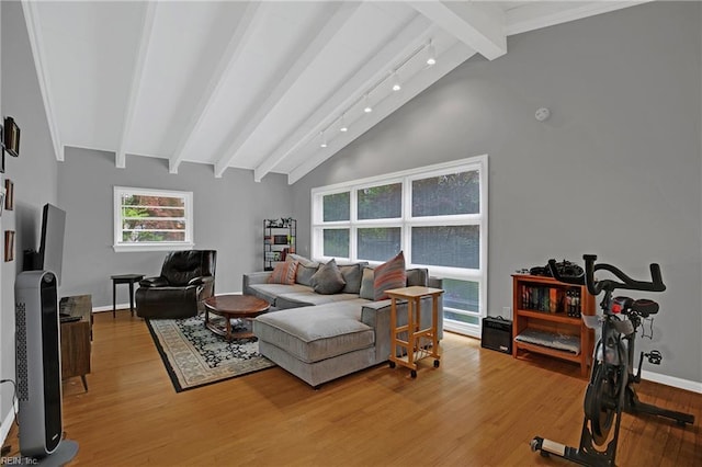 living room with lofted ceiling with beams, baseboards, and light wood-type flooring
