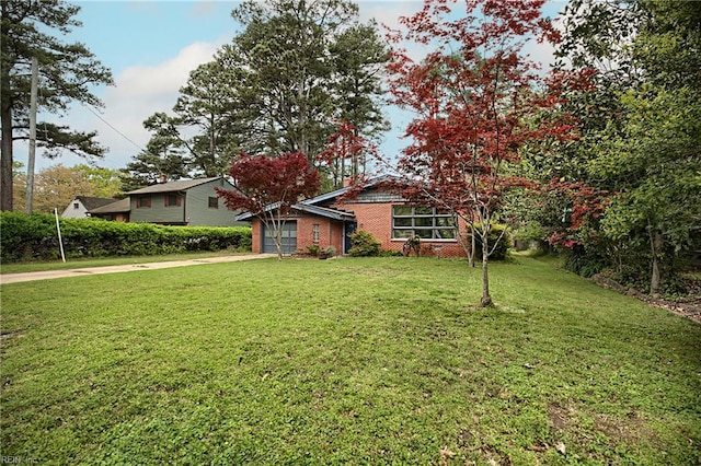 view of front of property with concrete driveway, brick siding, a garage, and a front yard
