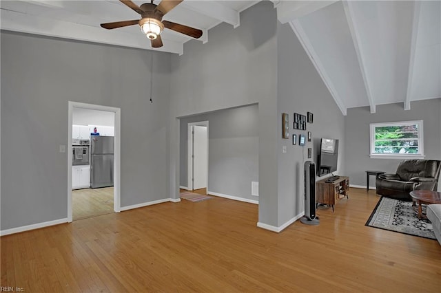 living room with beamed ceiling, light wood-style flooring, high vaulted ceiling, and ceiling fan