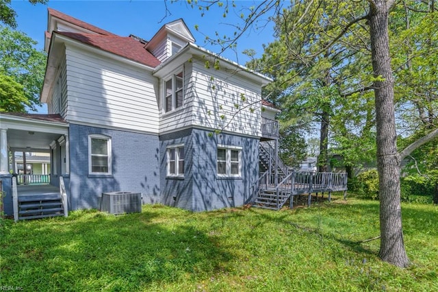 rear view of house with stairway, a yard, and central air condition unit