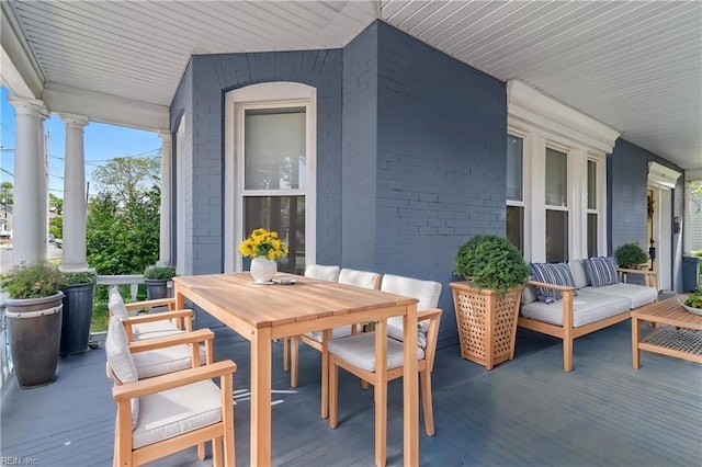 deck featuring outdoor dining space and a porch
