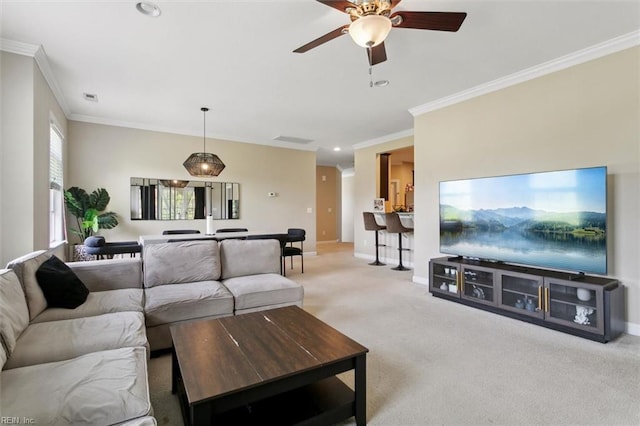 living room with visible vents, baseboards, a ceiling fan, crown molding, and light carpet