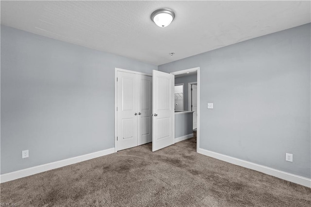 unfurnished bedroom with a closet, carpet, and baseboards