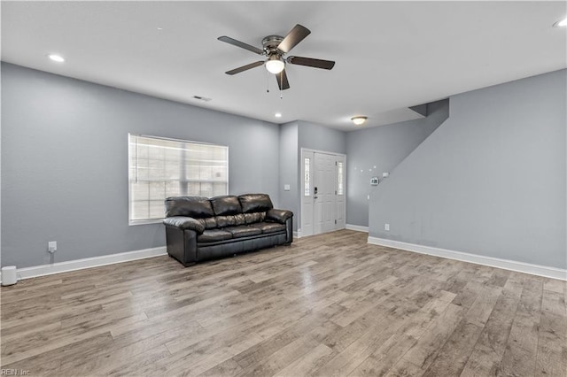 living area featuring ceiling fan, visible vents, and wood finished floors
