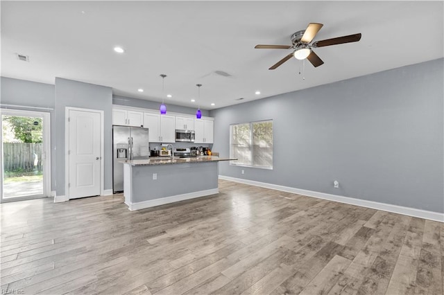 kitchen featuring open floor plan, appliances with stainless steel finishes, and a healthy amount of sunlight