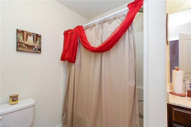 full bath featuring toilet, vanity, and a shower with curtain