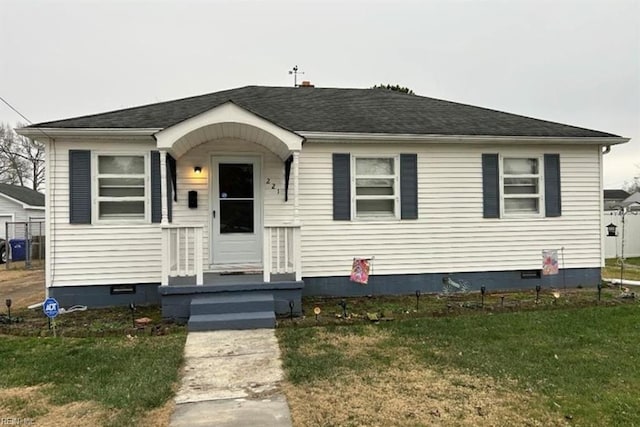 bungalow-style house featuring crawl space, roof with shingles, and a front lawn