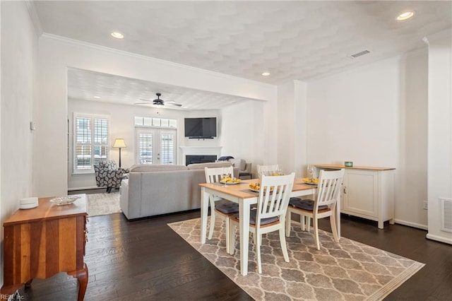 209 Cobblestone Reach Reach, Suffolk, VA 23435 - dining room with dark wood-style flooring, ornamental molding, a fireplace, visible vents, and ceiling fan