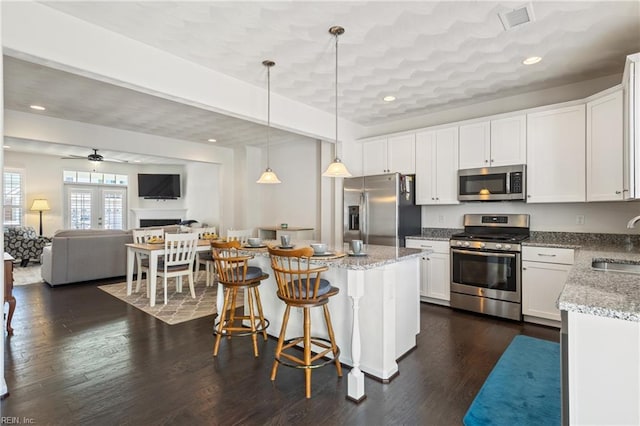 209 Cobblestone Reach Reach, Suffolk, VA 23435 - kitchen featuring white cabinetry, light stone counters, a sink, stainless steel appliances, and decorative light fixtures