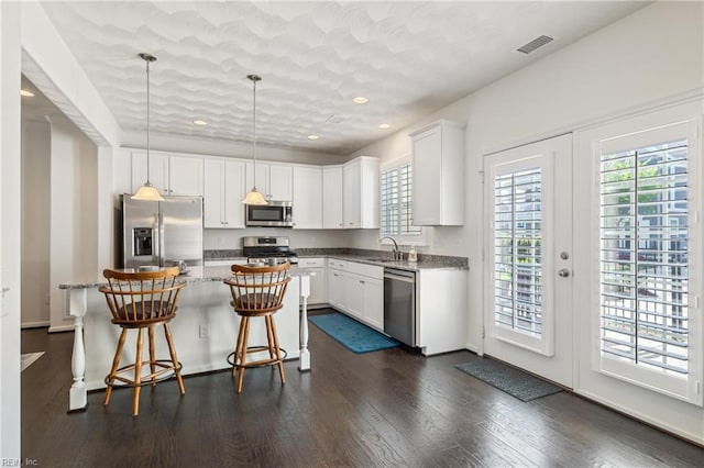 209 Cobblestone Reach Reach, Suffolk, VA 23435 - kitchen featuring white cabinetry, visible vents, dark wood finished floors, pendant lighting, and appliances with stainless steel finishes